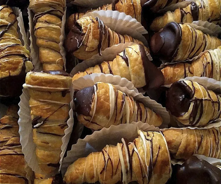 Caja con 24 cuernitos de hojaldre rellenos con crema pastelera